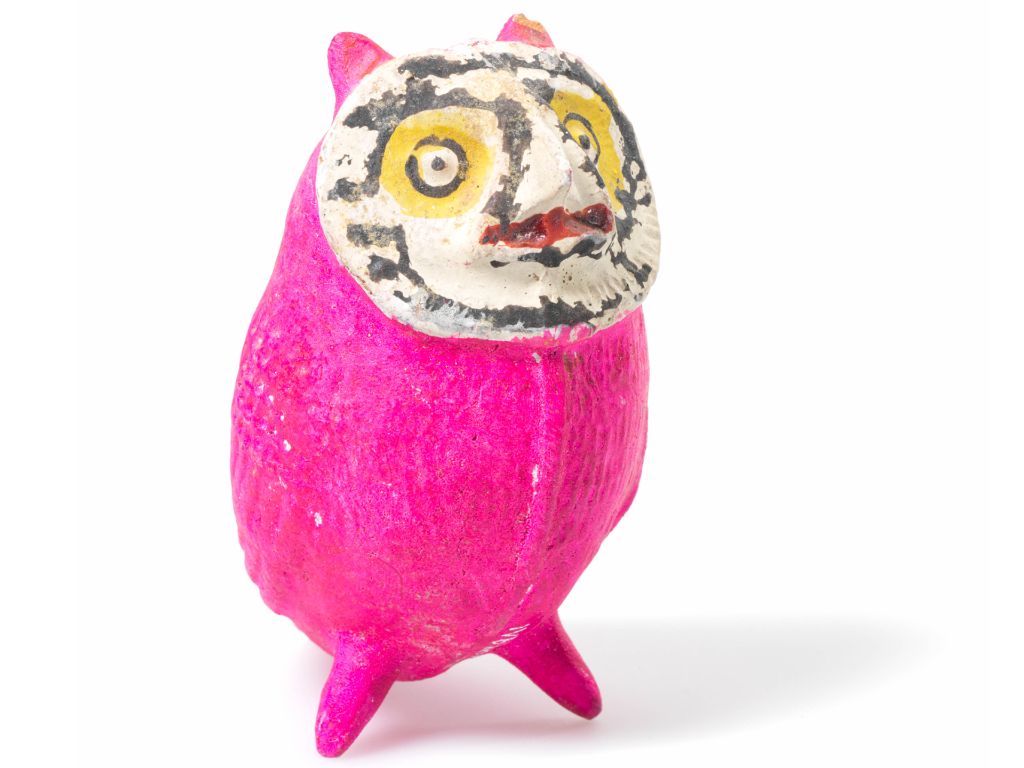 Eulenfigur mit weissem Gesicht, gelb umrahmten Augen und knallig pinkem Körper