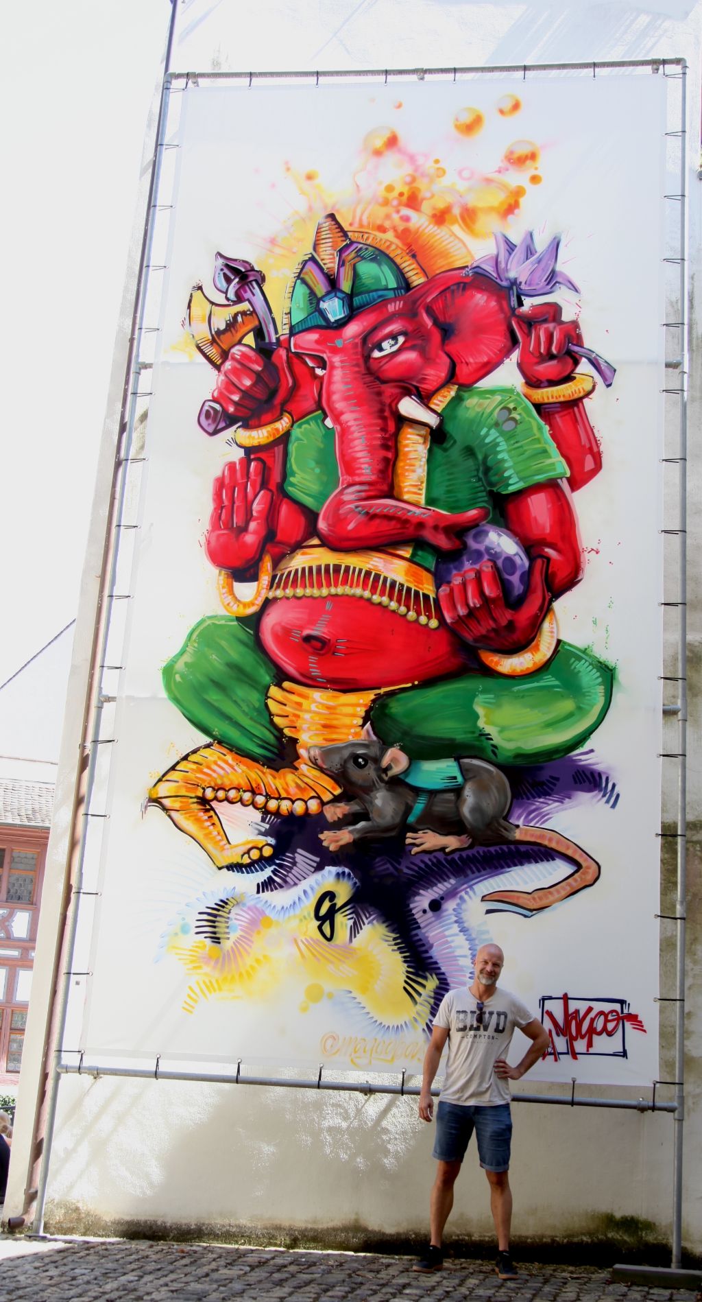 Magoo vor seinem Kunstwerk mit Ganesha und der Ratte im Museumshof