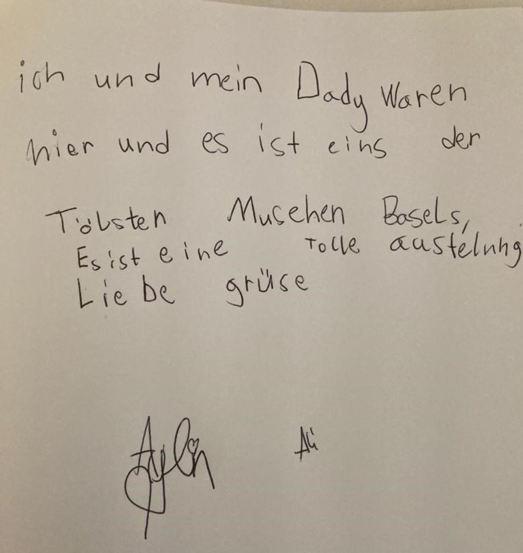 Seite eines Buches, auf der mit schwarzem Stift geschrieben steht: ich und mein Dady waren hier und es ist eines der tölsten Musehen Basels. Es ist eine tolle Austelung. Liebe Grüse Ali.